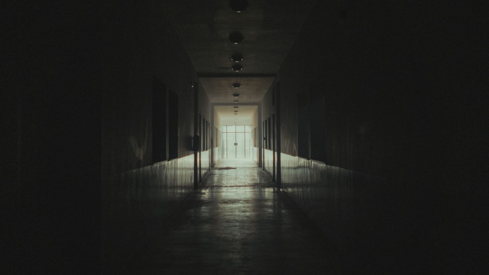 Long couloir sombre d'une maison, présence ressentie d'une entité