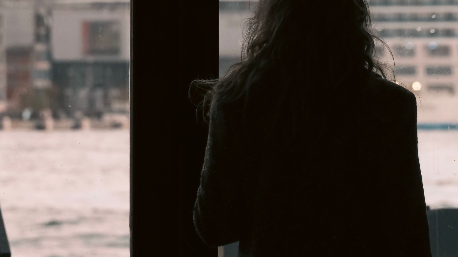 Femme sereine regardant par la fenêtre, soulagement après la levée d'un envoûtement