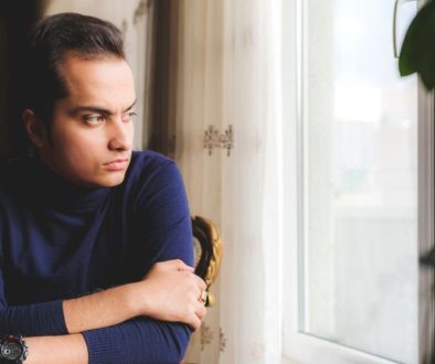 Homme pensif regardant par la fenetre, se demandant s'il est envoute